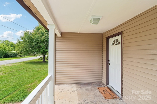 view of exterior entry with a yard