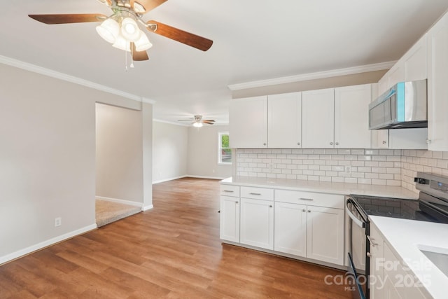 kitchen with appliances with stainless steel finishes, ceiling fan, ornamental molding, decorative backsplash, and light countertops