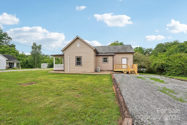 rear view of house with a lawn and a wooden deck