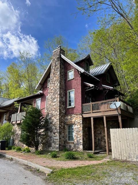 115 Breakaway Trl, Mars Hill, NC 28754 - view of side of home featuring stone siding, a chimney, a standing seam roof, metal roof, and fence