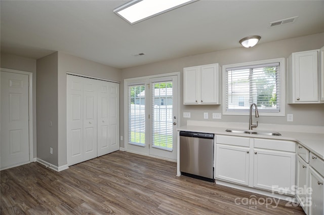 kitchen featuring dishwasher, a sink, white cabinets, wood finished floors, and light countertops