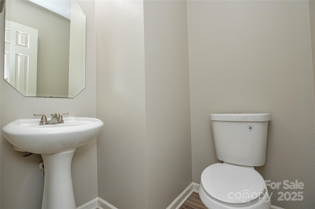 bathroom featuring toilet and baseboards