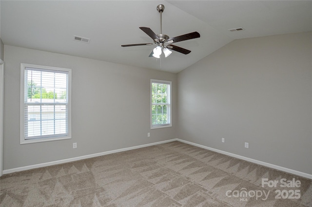 unfurnished room featuring lofted ceiling, light colored carpet, ceiling fan, and baseboards