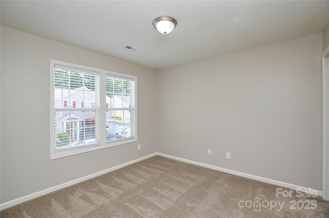 spare room with light colored carpet and baseboards