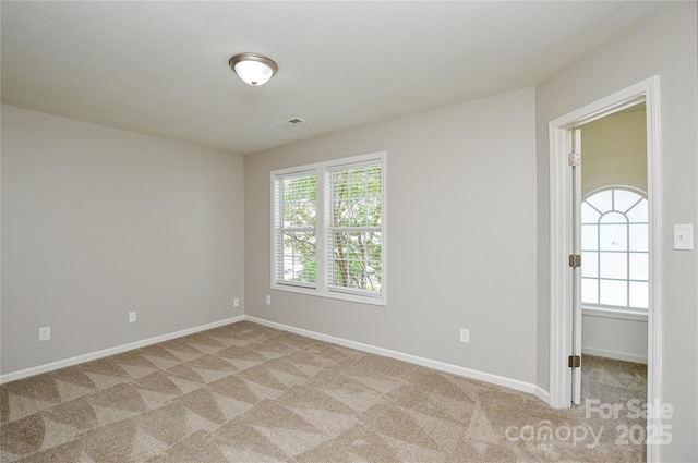 unfurnished room featuring light carpet, healthy amount of natural light, and baseboards