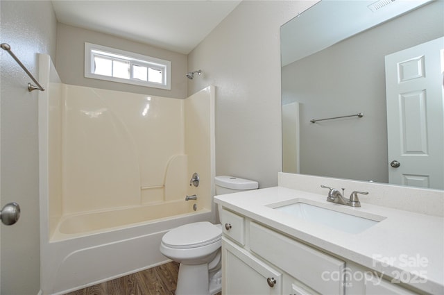 full bathroom with toilet, wood finished floors, vanity, and  shower combination