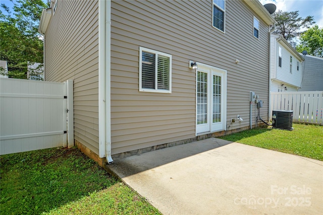 rear view of house with fence, central air condition unit, and a patio