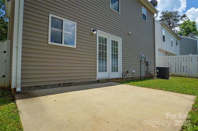 back of property featuring central AC, fence, and a patio area