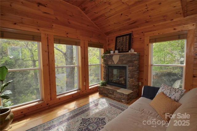 220 Woodwinds Ln, Seven Devils, NC 28604 - living area featuring vaulted ceiling, wood ceiling, wood walls, plenty of natural light, and a stone fireplace