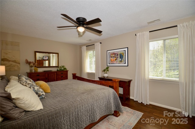 220 Woodwinds Ln, Seven Devils, NC 28604 - bedroom with multiple windows, wood finished floors, baseboards, ceiling fan, and a textured ceiling