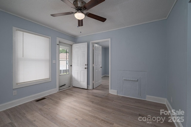 520 E Maple Ave, Gastonia, NC 28054 - unfurnished room with wood finished floors, a textured ceiling, ceiling fan, baseboards, and ornamental molding