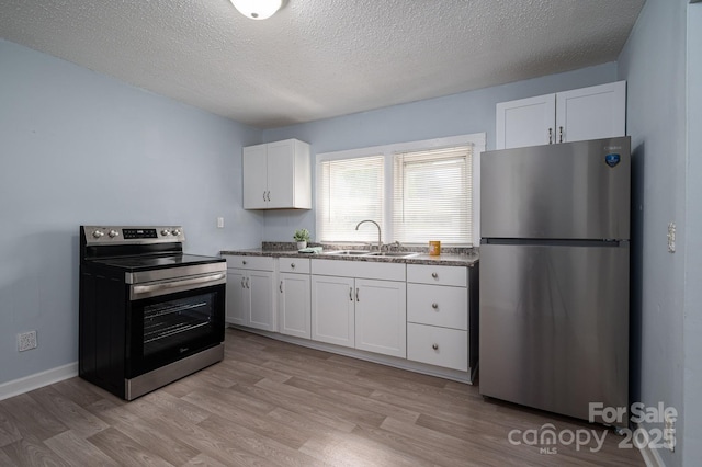 520 E Maple Ave, Gastonia, NC 28054 - kitchen with stainless steel appliances, light wood-type flooring, white cabinets, a textured ceiling, and a sink