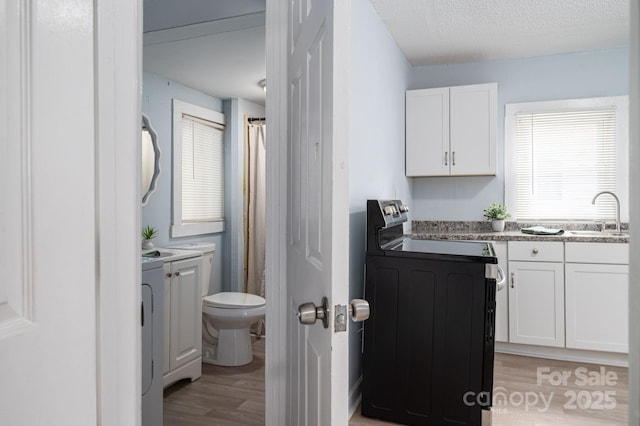 520 E Maple Ave, Gastonia, NC 28054 - full bathroom with wood finished floors, toilet, vanity, a shower with curtain, and washer / dryer