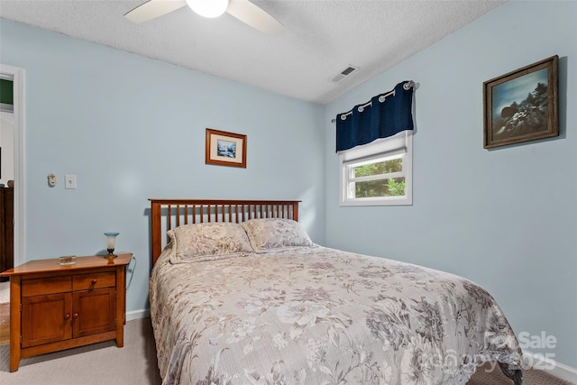 carpeted bedroom with baseboards, a textured ceiling, and a ceiling fan