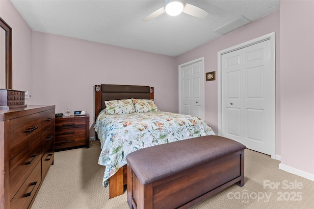 bedroom featuring light colored carpet, baseboards, and a ceiling fan