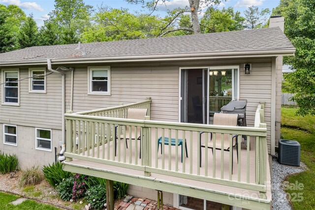 back of property with central AC, a wooden deck, a chimney, and roof with shingles