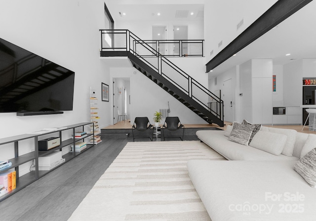 2913 Lake Ave, Charlotte, NC 28208 - living area with stairs, a high ceiling, recessed lighting, and wood finished floors