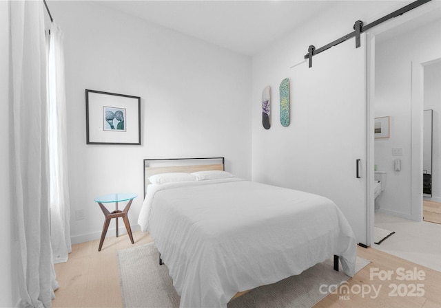 2913 Lake Ave, Charlotte, NC 28208 - bedroom with a barn door and light wood finished floors
