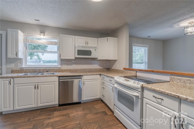 133 Pheasant Run Rd, Troutman, NC 28166 - kitchen with white appliances, a sink, a textured ceiling, dark wood-style floors, and white cabinetry