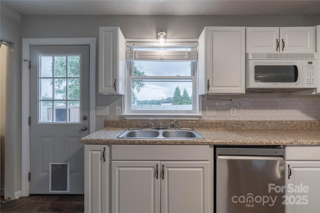 133 Pheasant Run Rd, Troutman, NC 28166 - kitchen with white microwave, stainless steel dishwasher, a sink, white cabinetry, and light countertops