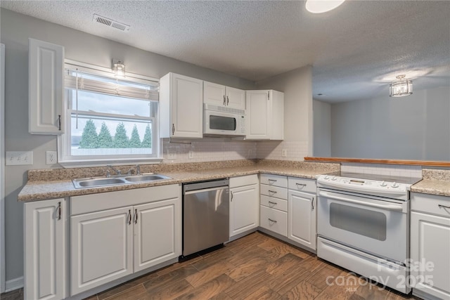 133 Pheasant Run Rd, Troutman, NC 28166 - kitchen with white appliances, a sink, a textured ceiling, white cabinetry, and tasteful backsplash