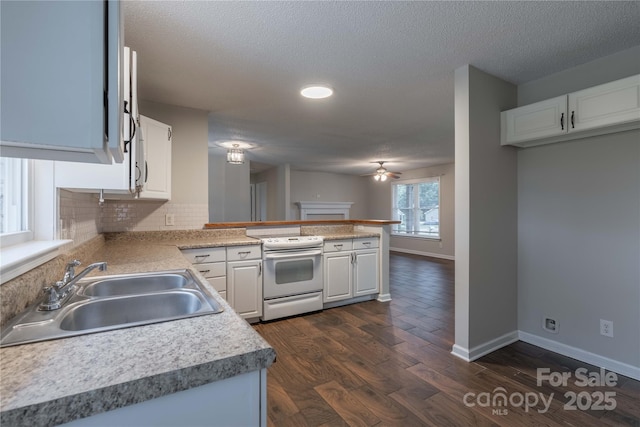 133 Pheasant Run Rd, Troutman, NC 28166 - kitchen with white range with electric stovetop, a sink, a peninsula, decorative backsplash, and white cabinetry