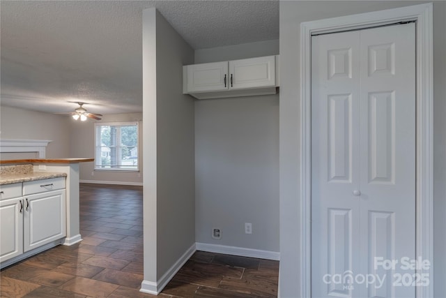 133 Pheasant Run Rd, Troutman, NC 28166 - kitchen featuring ceiling fan, a textured ceiling, baseboards, and white cabinetry