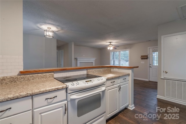 133 Pheasant Run Rd, Troutman, NC 28166 - kitchen with white range with electric cooktop, a ceiling fan, dark wood-type flooring, light countertops, and white cabinetry