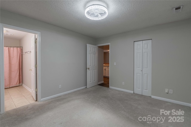 133 Pheasant Run Rd, Troutman, NC 28166 - unfurnished bedroom featuring carpet flooring, a closet, baseboards, and a textured ceiling