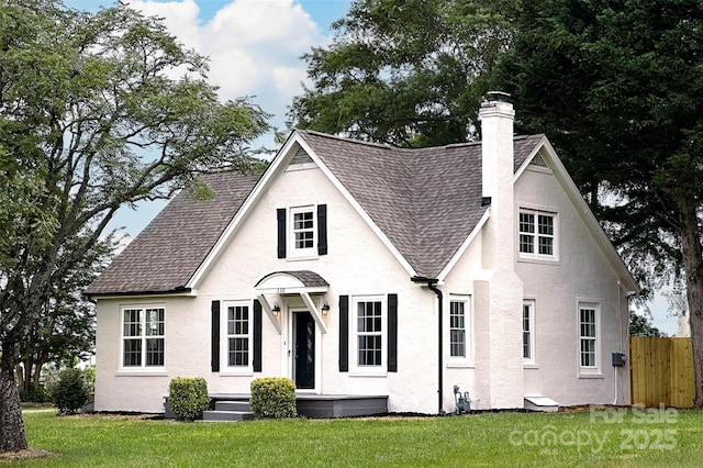 view of front of property featuring roof with shingles, a chimney, and stucco siding