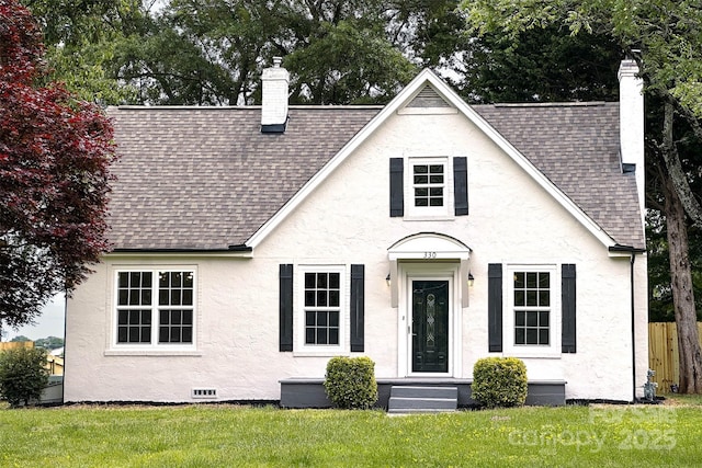 view of front facade featuring a chimney, roof with shingles, and stucco siding