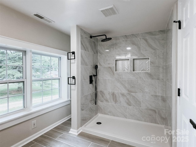 bathroom with baseboards and a tile shower
