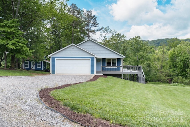 view of front of home featuring gravel driveway, a porch, a front lawn, and an attached garage