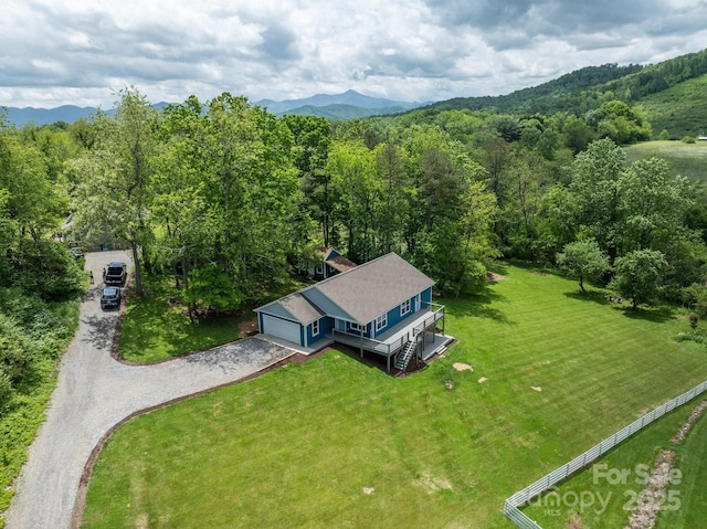 aerial view of property and surrounding area with a heavily wooded area and mountains