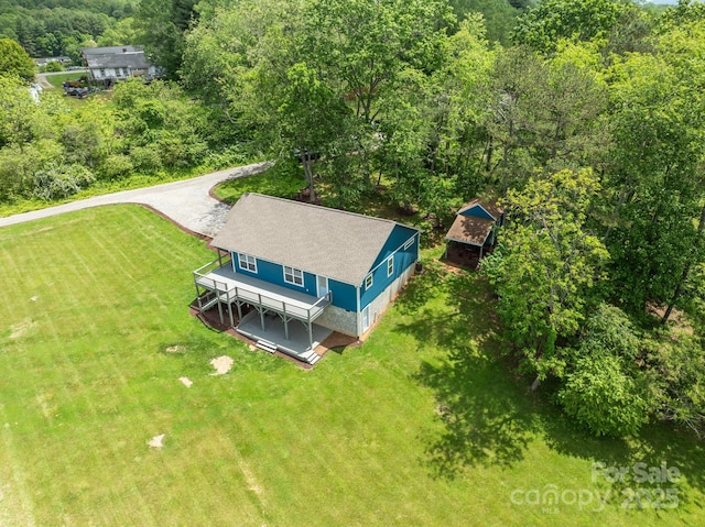 aerial view of property and surrounding area featuring a heavily wooded area