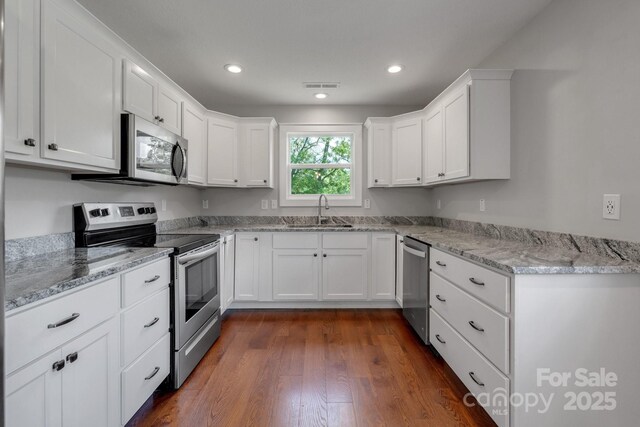 123 Dapple Rd, Candler, NC 28715 - kitchen with appliances with stainless steel finishes, a sink, white cabinets, dark wood-style flooring, and recessed lighting