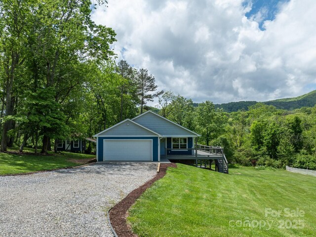 123 Dapple Rd, Candler, NC 28715 - single story home with a front yard, gravel driveway, a forest view, an attached garage, and stairway