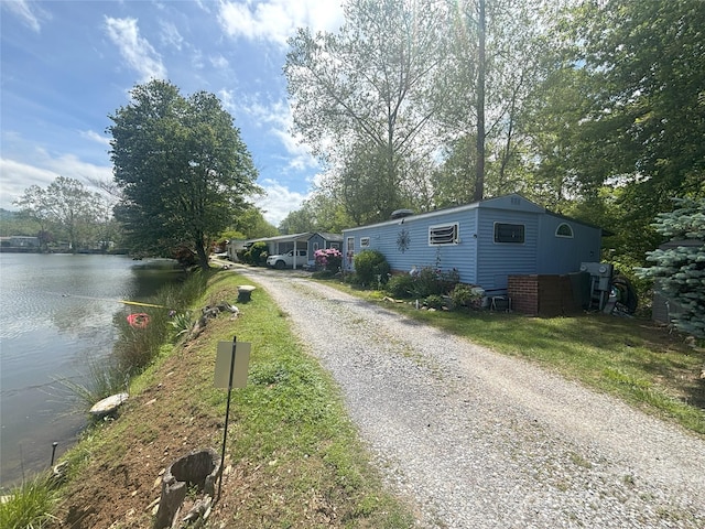 view of dirt / gravel driveway with a water view