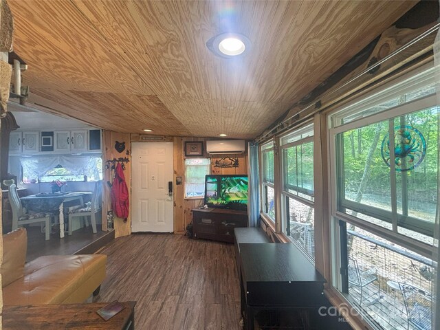 living area with wooden ceiling, a wall unit AC, and dark wood-style floors