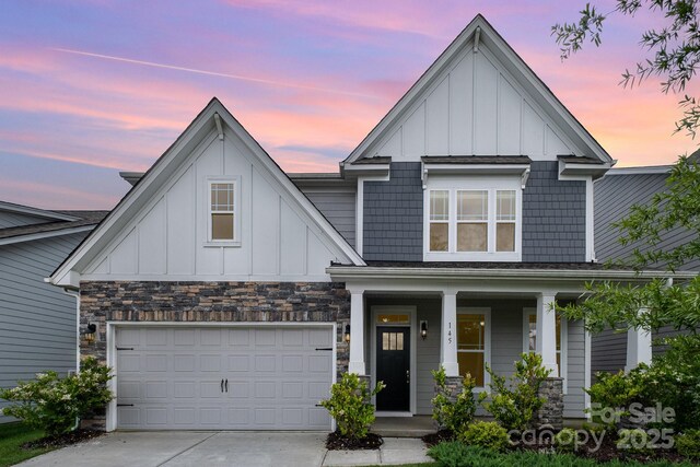 145 Yellow Birch Loop, Mooresville, NC 28117 - view of front facade with board and batten siding, a porch, concrete driveway, and stone siding