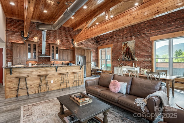 14 N Main St Unit 2, Waynesville, NC 28786 - living room featuring high vaulted ceiling, brick wall, light wood-type flooring, plenty of natural light, and wooden ceiling