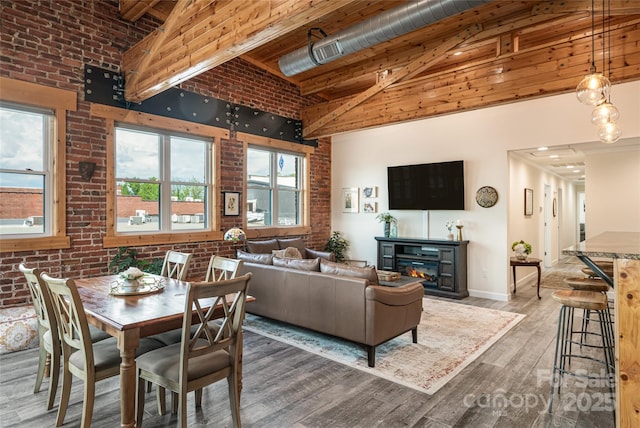 14 N Main St Unit 2, Waynesville, NC 28786 - dining space with high vaulted ceiling, brick wall, wood finished floors, baseboards, and beam ceiling