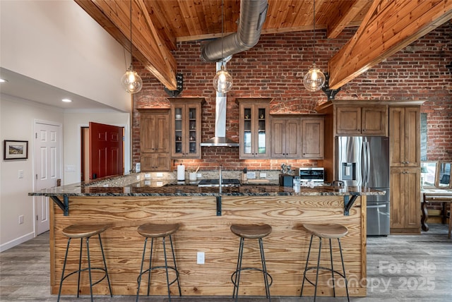 14 N Main St Unit 2, Waynesville, NC 28786 - kitchen with stainless steel refrigerator with ice dispenser, wall chimney exhaust hood, a high ceiling, a breakfast bar, and dark stone countertops
