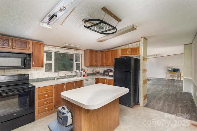 kitchen featuring black appliances, a sink, light countertops, lofted ceiling, and a textured ceiling
