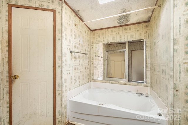 bathroom with wallpapered walls, a bath, crown molding, and a textured ceiling