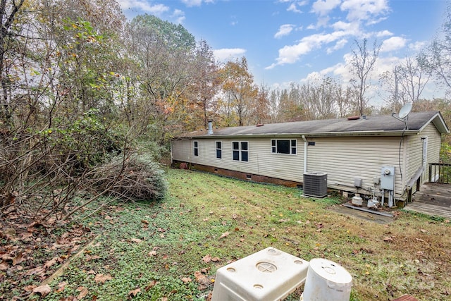 rear view of house featuring crawl space, a lawn, and central AC