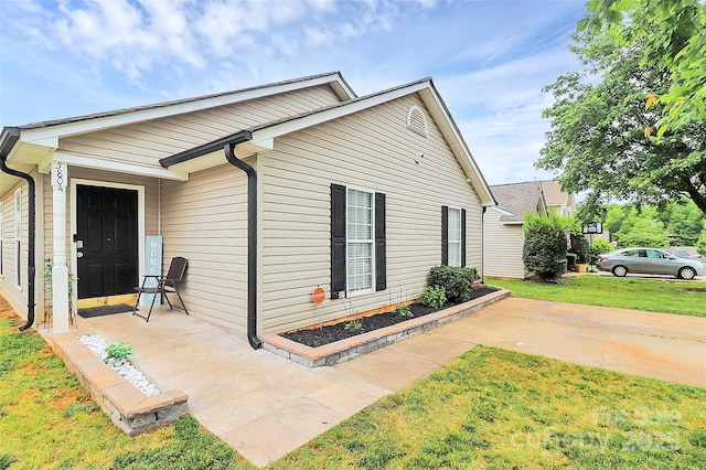 view of side of home with a yard