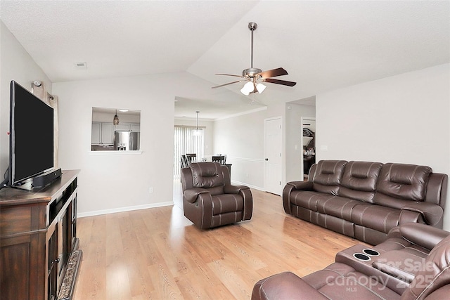 living room featuring light wood-style flooring, a ceiling fan, vaulted ceiling, and baseboards