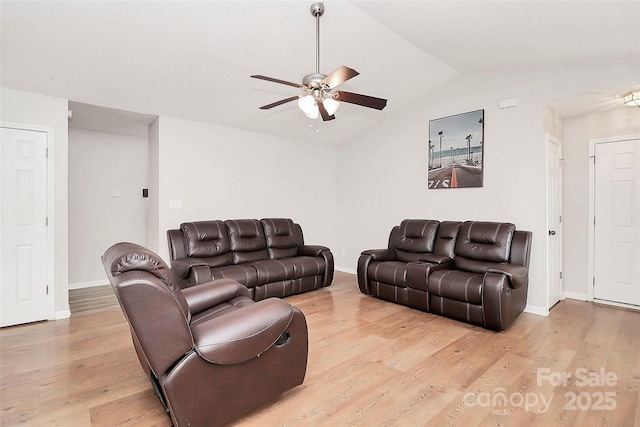 living area featuring ceiling fan, light wood-type flooring, vaulted ceiling, and baseboards