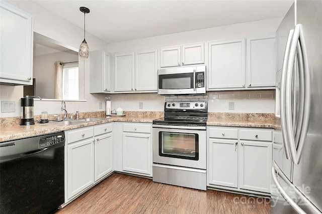 kitchen with appliances with stainless steel finishes, a sink, tasteful backsplash, and light countertops
